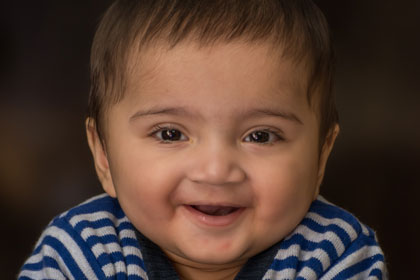 Young boy toddler smiling at the camera.